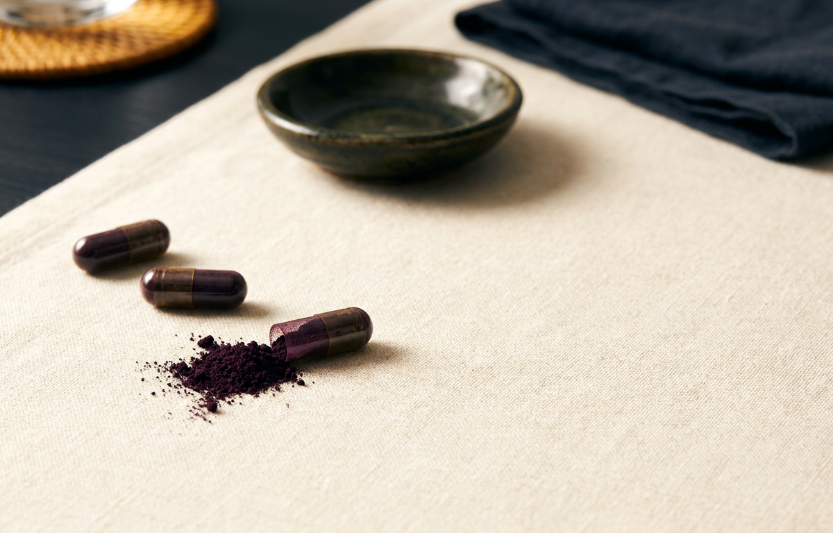 Primo piano di capsule di estratto di acai su un fondo di fibre naturali